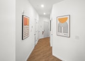 Thumbnail 15 of 30 - A hallway with two paintings on the wall.