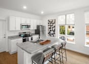 Thumbnail 14 of 30 - A kitchen with white cabinets and a grey countertop.