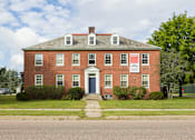 Thumbnail 7 of 24 - A red brick building with a sign on the front.