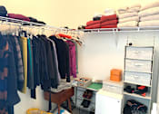 Thumbnail 15 of 17 - Clothes hanging on a rack in a room.