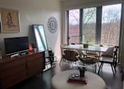 Thumbnail 9 of 17 - A living room with a white table and chairs.
