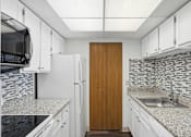 Thumbnail 117 of 151 - A kitchen with a wooden door and a sink.