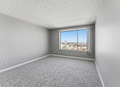 Thumbnail 126 of 151 - A room with a window overlooking a cityscape.
