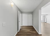 Thumbnail 139 of 151 - A long, narrow hallway with white walls and wood flooring.