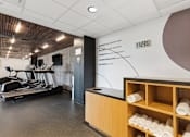 Thumbnail 73 of 151 - A gym with a treadmill, weights and a wall with a sign.