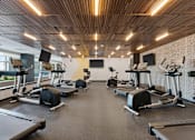 Thumbnail 75 of 151 - A gym with treadmills, elliptical machines, and other exercise equipment.