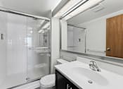 Thumbnail 130 of 151 - A modern bathroom with a white sink and a walk-in shower.
