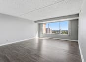 Thumbnail 113 of 151 - A spacious room with a view of the city through a large window.