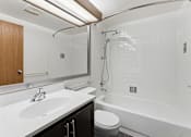 Thumbnail 124 of 151 - A white bathroom with a toilet, sink, and bathtub.