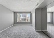 Thumbnail 100 of 151 - A spacious room with a large window and a carpeted floor.