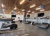 Thumbnail 78 of 151 - A gym with treadmills, exercise bikes, and other equipment.