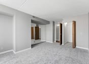 Thumbnail 99 of 151 - A spacious room with a carpeted floor and white walls.