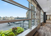 Thumbnail 68 of 151 - A long hallway with a view of the city outside the windows.