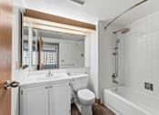 Thumbnail 101 of 151 - A white bathroom with a toilet, sink, and bathtub.