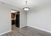 Thumbnail 114 of 151 - A room with a black refrigerator and wooden flooring.