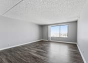 Thumbnail 135 of 151 - A room with a large window and wooden flooring.