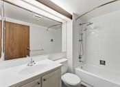 Thumbnail 122 of 151 - A white bathroom with a toilet, sink, and bathtub.