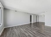Thumbnail 133 of 151 - A room with wooden flooring and white walls.
