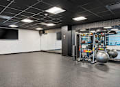 Thumbnail 69 of 151 - A spacious gym with a variety of equipment including a treadmill, weights, and a television.
