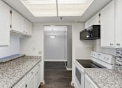 Thumbnail 98 of 151 - A kitchen with granite countertops and white cabinets.