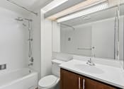 Thumbnail 105 of 151 - A white bathroom with a toilet, sink, and bathtub.