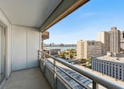 Thumbnail 97 of 151 - A balcony with a metal railing overlooks a cityscape.