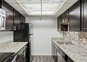 Thumbnail 132 of 151 - A kitchen with black cabinets and granite countertops.