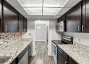 Thumbnail 131 of 151 - A kitchen with black cabinets and a white door in the background.