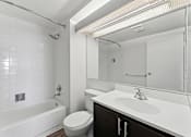 Thumbnail 141 of 151 - A white bathroom with a toilet, sink, and bathtub.