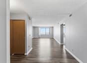 Thumbnail 129 of 151 - A long hallway with a brown door on the left.