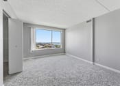 Thumbnail 142 of 151 - A room with a large window overlooking a cityscape.