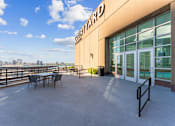 Thumbnail 60 of 151 - A patio area with a table and chairs outside a building with a sign that says "Fourward".