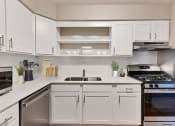 Thumbnail 2 of 38 - a white kitchen with stainless steel appliances and white cabinets