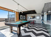 Thumbnail 48 of 151 - A pool table is in the middle of a room with a chevron patterned floor.