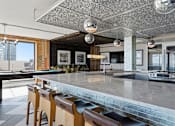 Thumbnail 54 of 151 - A kitchen with a bar area and wooden chairs.