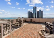 Thumbnail 47 of 151 - A rooftop patio with a table and chairs overlooking a city skyline.