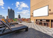 Thumbnail 46 of 151 - A rooftop patio with a table and chairs and a blank billboard.
