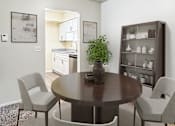Thumbnail 2 of 26 - A dining room with a round table and chairs.
