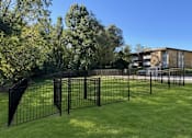 Thumbnail 26 of 29 - A black metal fence surrounds a green lawn.