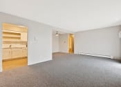 Thumbnail 7 of 38 - the living room and kitchen of an apartment with a carpeted floor