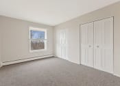 Thumbnail 9 of 38 - a bedroom with two closet doors and a window