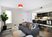 Thumbnail 2 of 32 - a living room with a couch in front of a kitchen