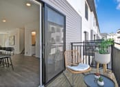 Thumbnail 17 of 46 - a balcony with a chair and a table and a sliding glass door