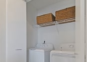 Thumbnail 27 of 46 - a small laundry room with a white washer and dryer and a white refrigerator