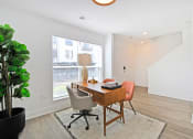 Thumbnail 28 of 46 - a home office with a large window and a desk with two chairs