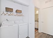 Thumbnail 39 of 46 - a white washer and dryer in a room with a door to a bathroom