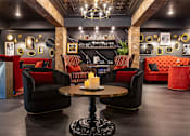 Thumbnail 45 of 46 - A room with a black table and chairs with red cushions.