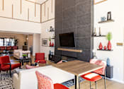 Thumbnail 37 of 46 - A living room with a fireplace and a TV on the wall.