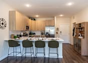 Thumbnail 27 of 46 - A kitchen with a white countertop and a clock on the wall.