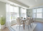 Thumbnail 11 of 26 - a dining room with a table and chairs and windows